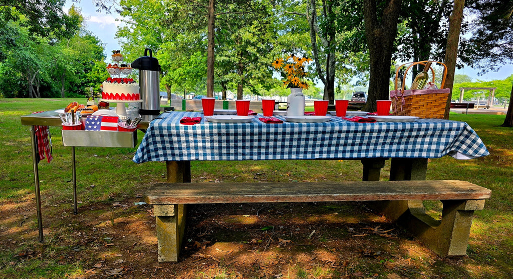 The Big John Table extending a picnic table as a dessert and serving station with a layered cake and coffee