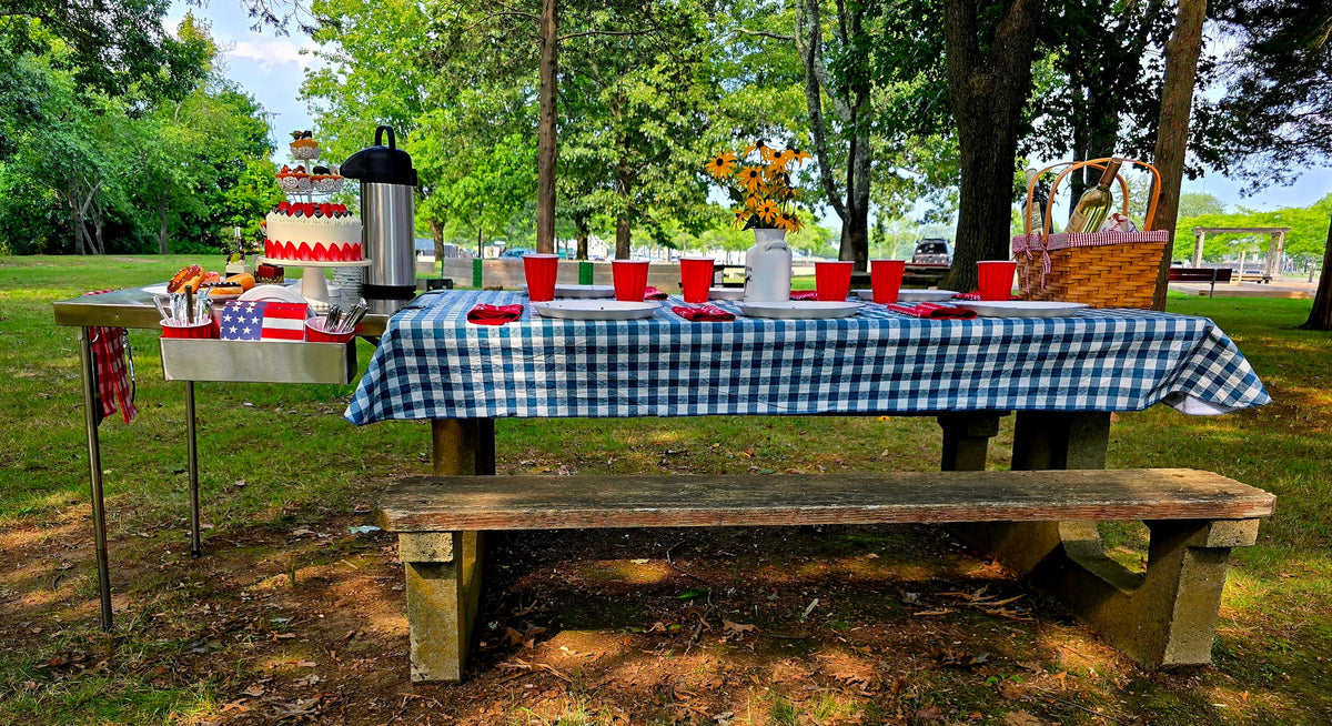 The Big John Table extending a picnic table as a dessert and serving station with a layered cake and coffee